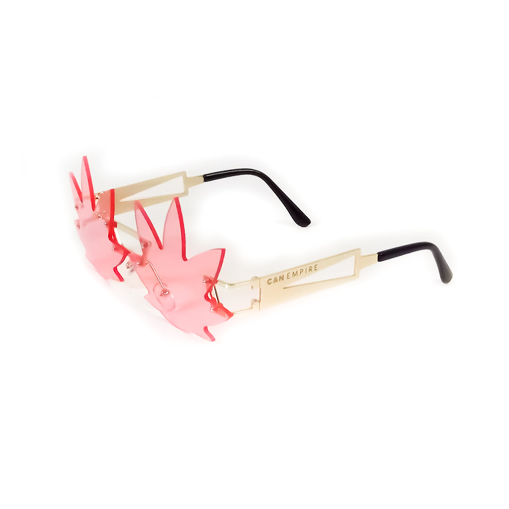 Image des lunettes de soleil de CanEmpire rappelant la forme de feuilles de cannabis. Ces lunettes idéales pour la saison estivale et les festivals sont disponibles en rose et en vert, en plus d'être accompagnées d'une étui de cuir synthétique écologique.